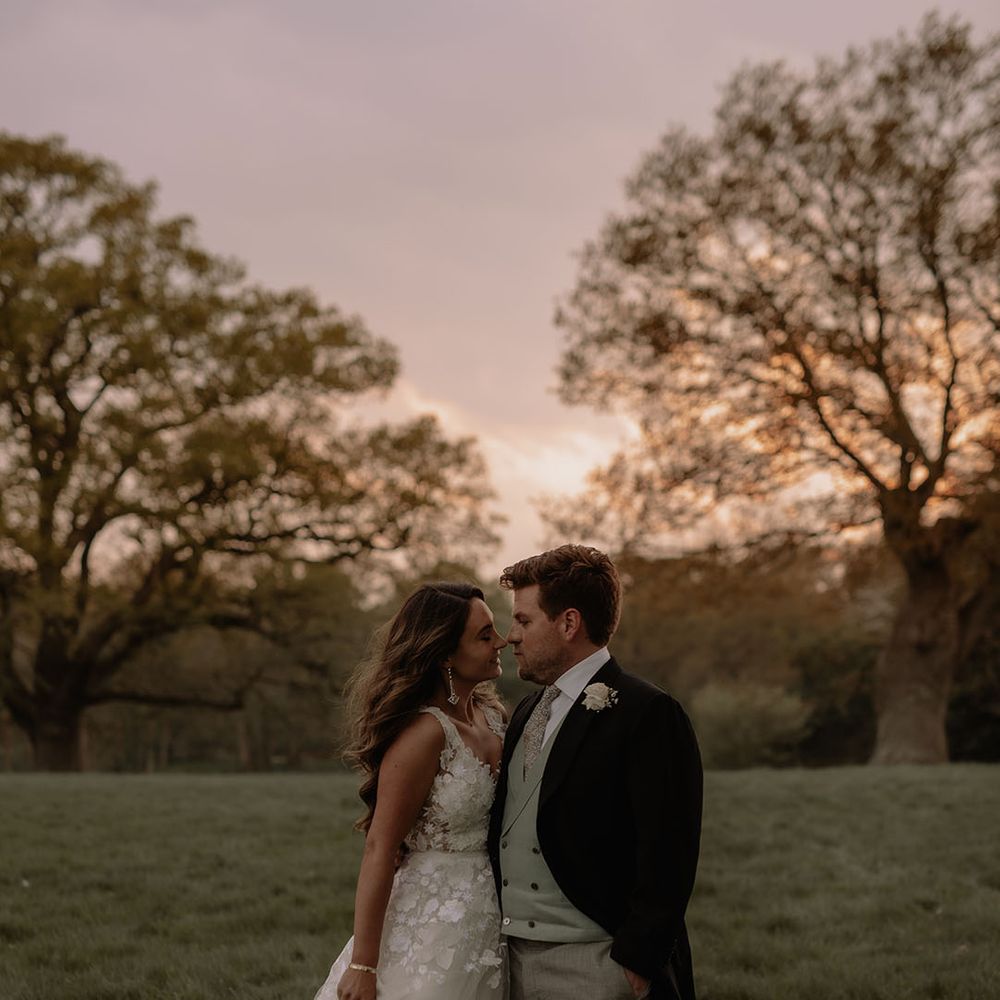 Groom in morning suit with green waistcoat, floral tie and puppytooth trousers with bride in Mira Zwillinger flora applique wedding dress 