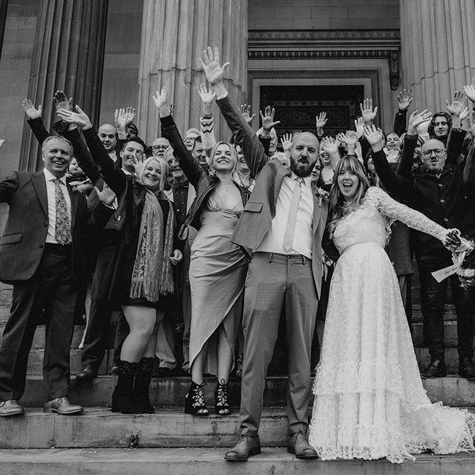 Bride & groom stand with wedding party in front of St. George's Hall in Liverpool after civil ceremony 