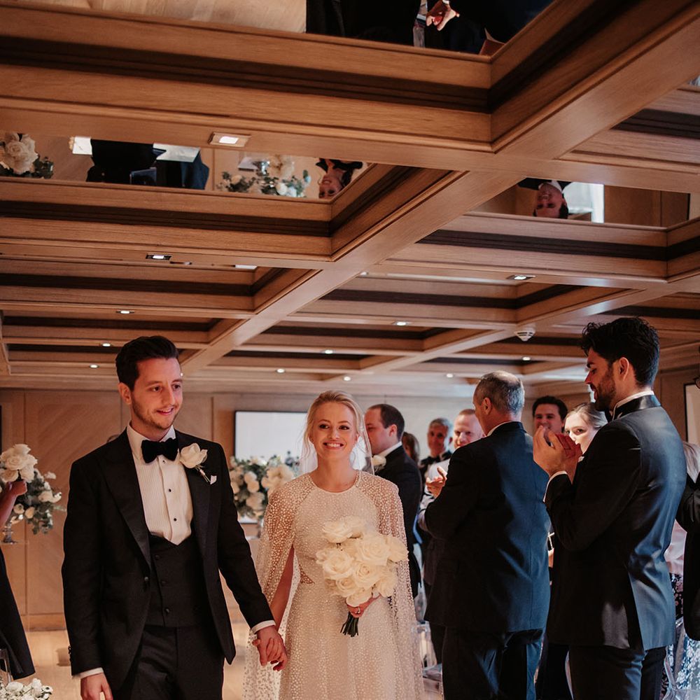 Bride and groom smile as they walk back down the aisle as a married couple 