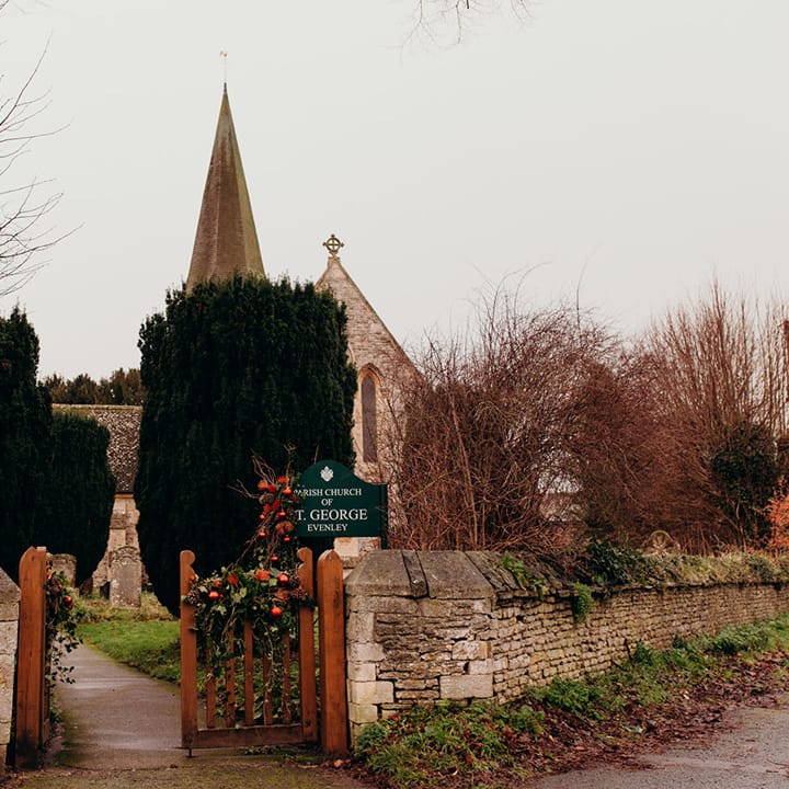Exterior or parish church with winter foliage decorations on the front of the gate 