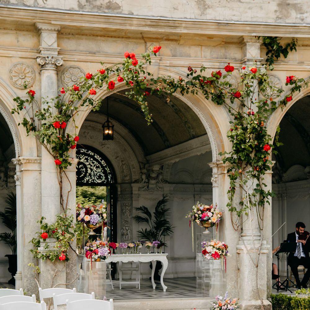 Purple, red, orange, and pink wedding flowers decorate the outdoor space at North Mymms Park for bright summer wedding