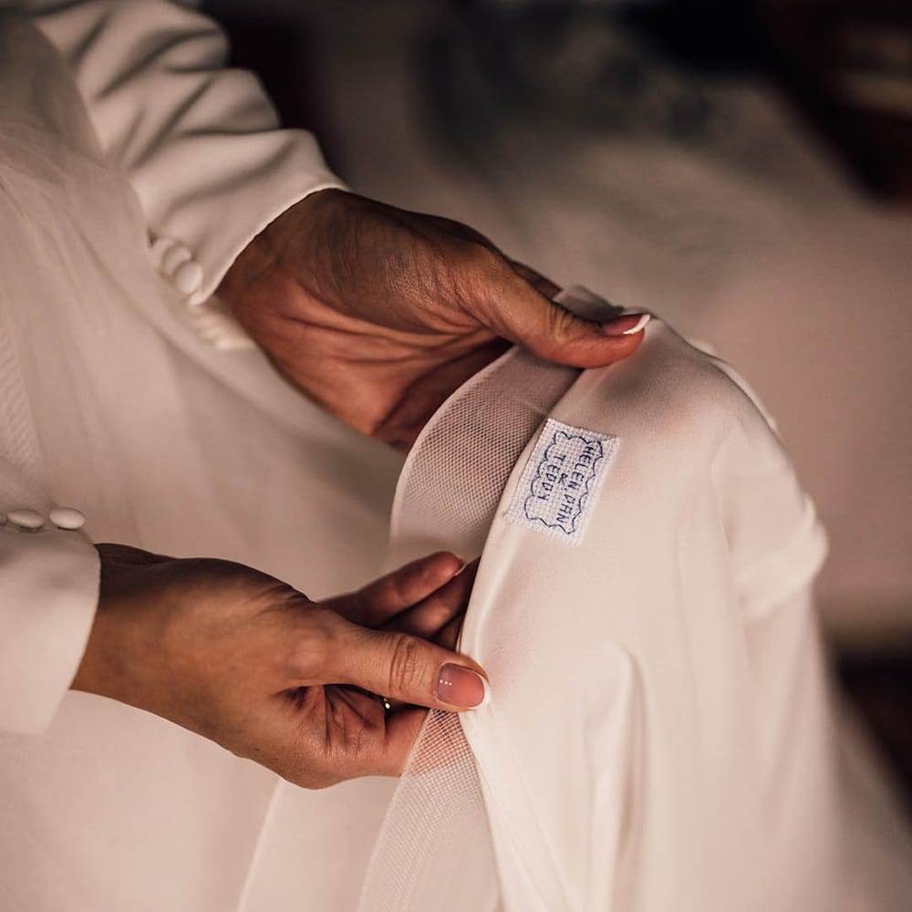 Bride wearing a layered wedding dress with personalised label with the bride, groom and their son's names