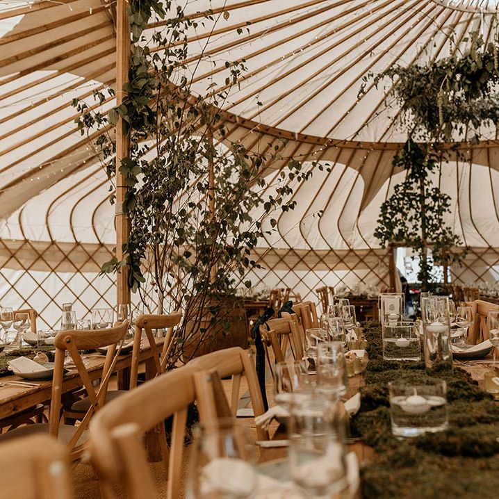 Yurt wedding reception venue for Camp Katur wedding in Yorkshire decorated with lots of foliage and greenery 