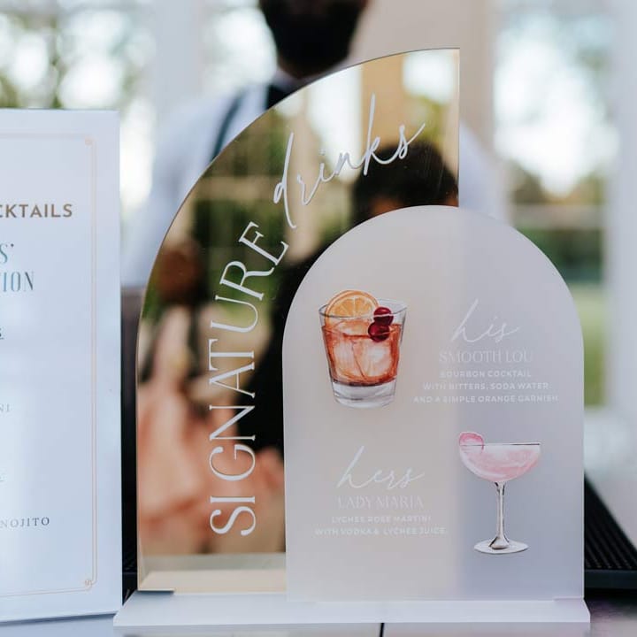 Mirrored acrylic wedding cocktail sign at Syon Park with pink wedding cocktails next to it