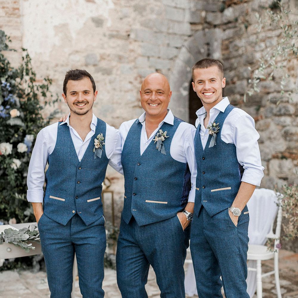Groom and groomsman in blue waistcoat with blue buttonhole 