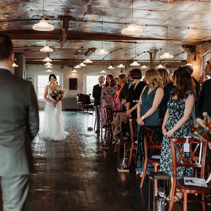 The bride walks herself down the aisle at the industrial wedding venue 