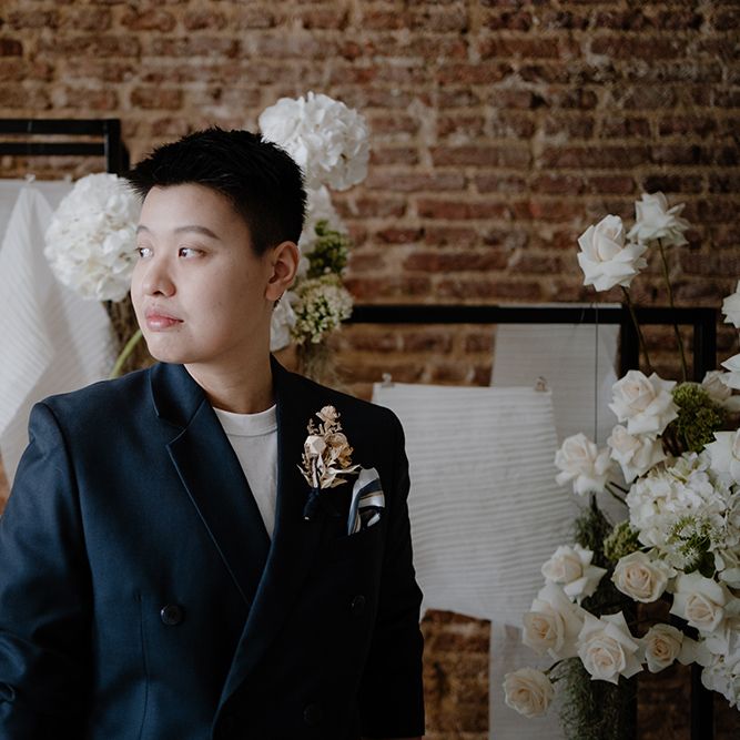 Asian Lesbian bride in a white t shirt and navy suit jacket 