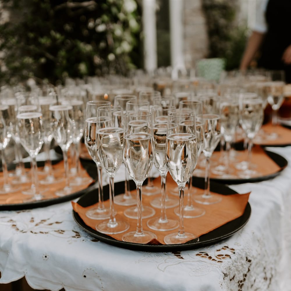Trays of champagne flutes filled with sparkling wine at garden wedding in Bedfordshire