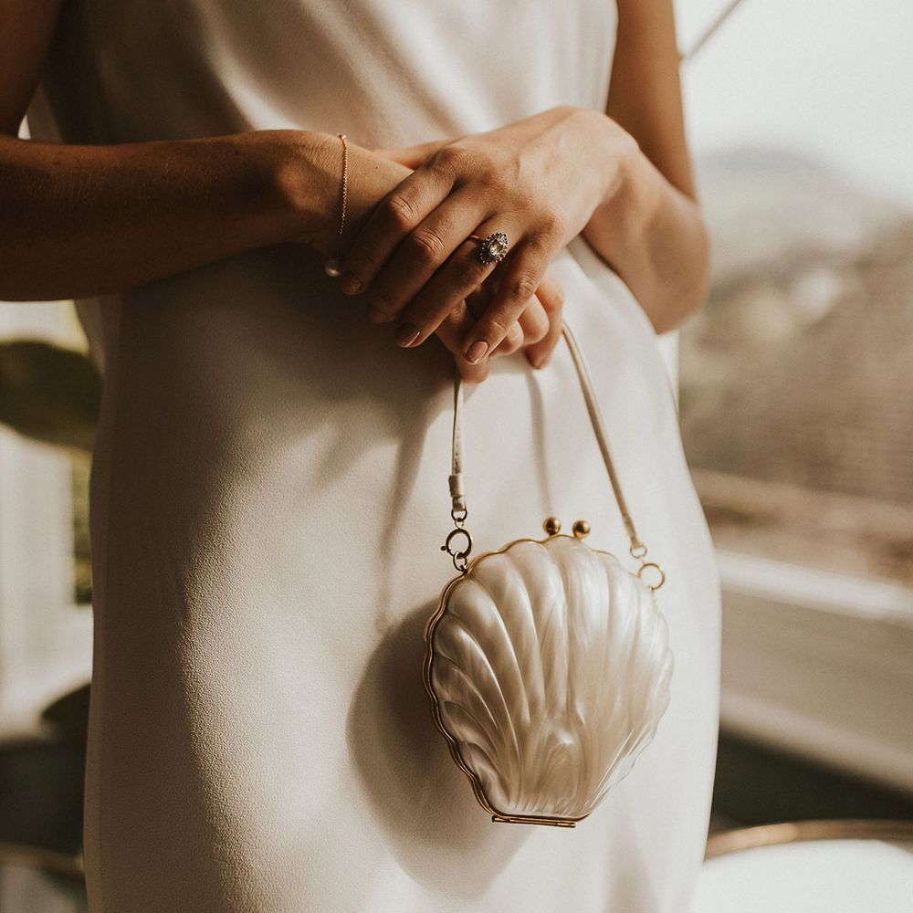 Bride holding a Lulu Guinness shell clutch bag bridal accessory 