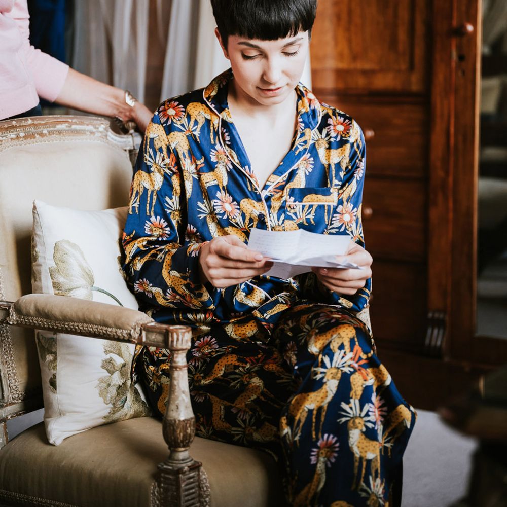 Bride with short brown hair in dark blue satin pyjamas on the wedding morning 