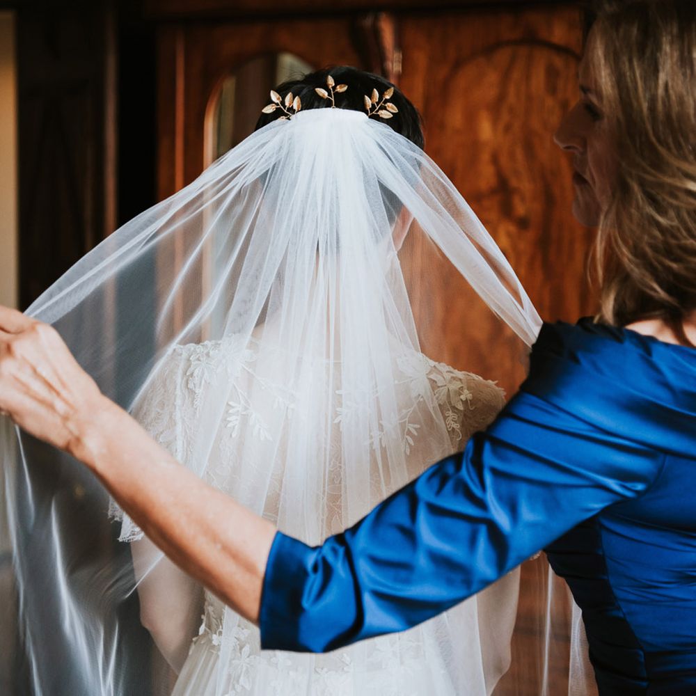 Bride putting on her cathedral length wedding veil 