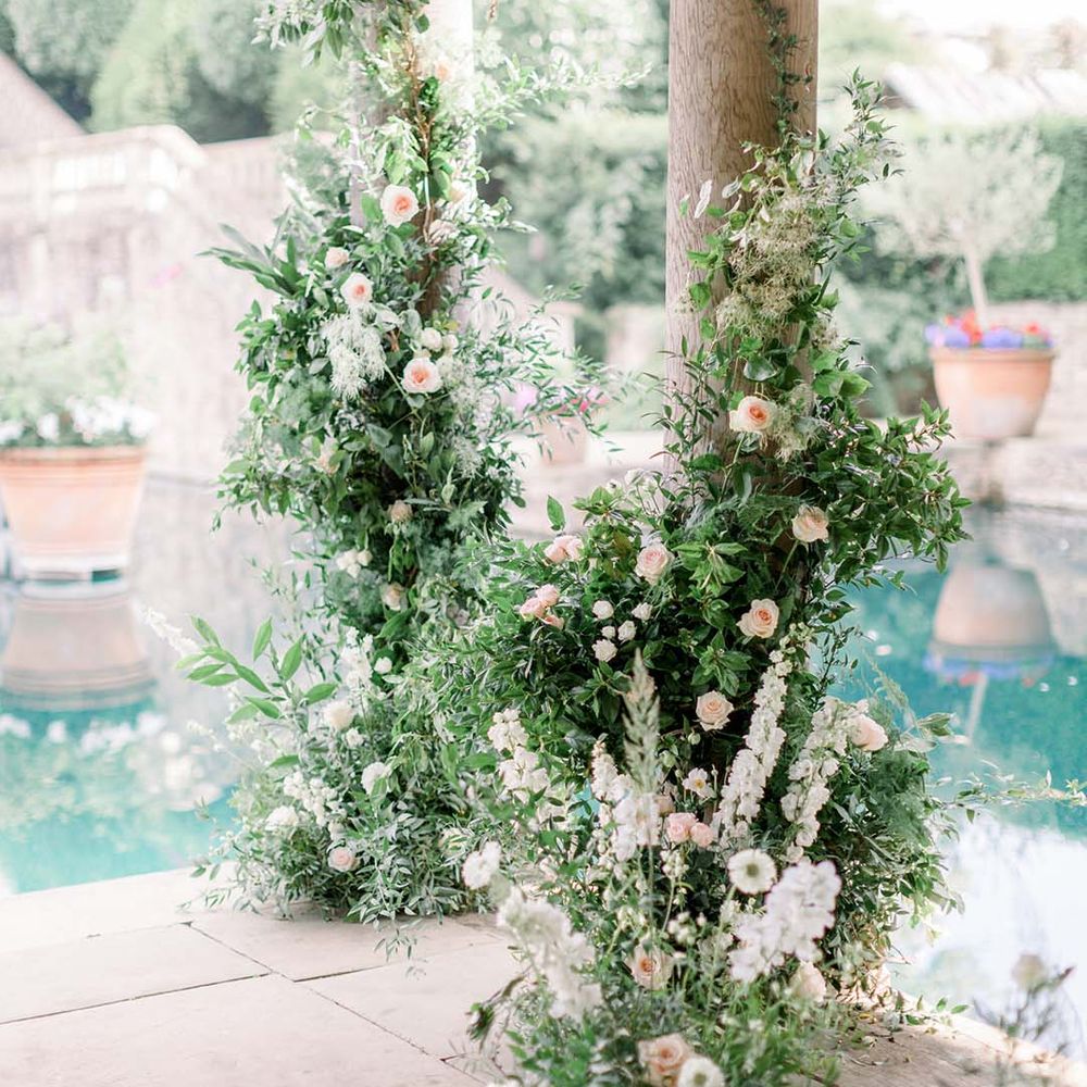 Green foliage outdoors complete with pastel florals against pillars 