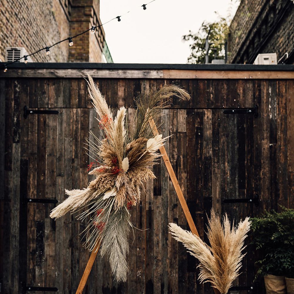 Wooden framed altar decorated with dried pampas grass, palm leaves and foliage 
