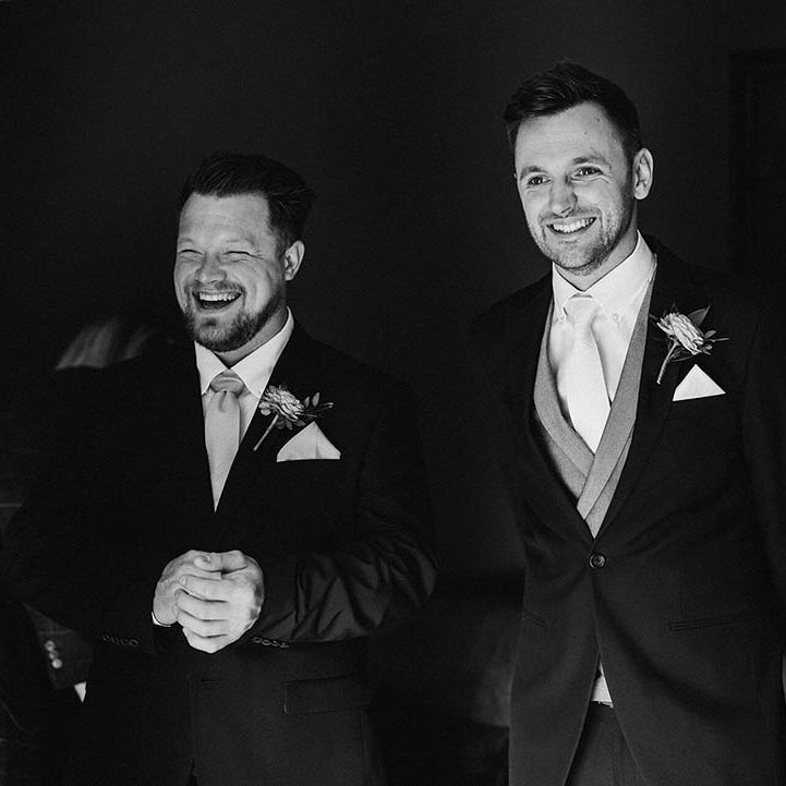 Groom and groomsmen in black three piece suit 