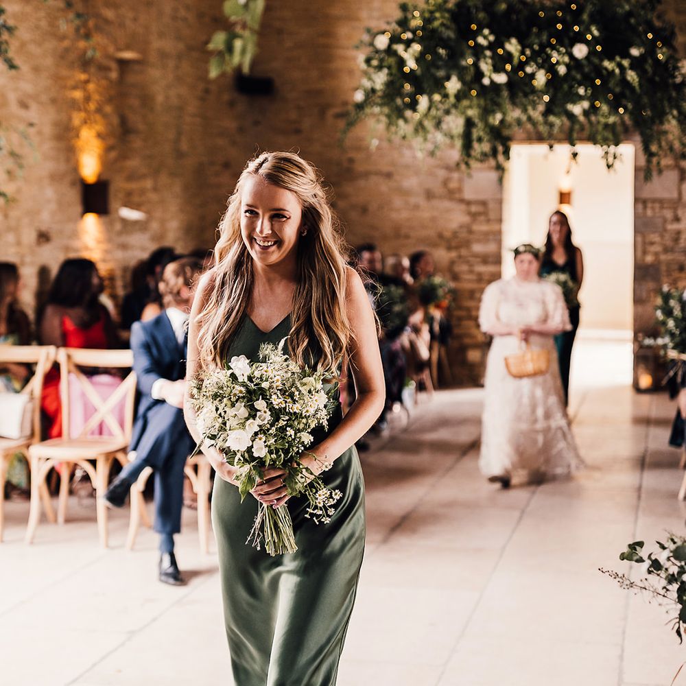 Bridesmaid in a green satin dress from Rewritten Bridesmaids with a white flower bouquet 