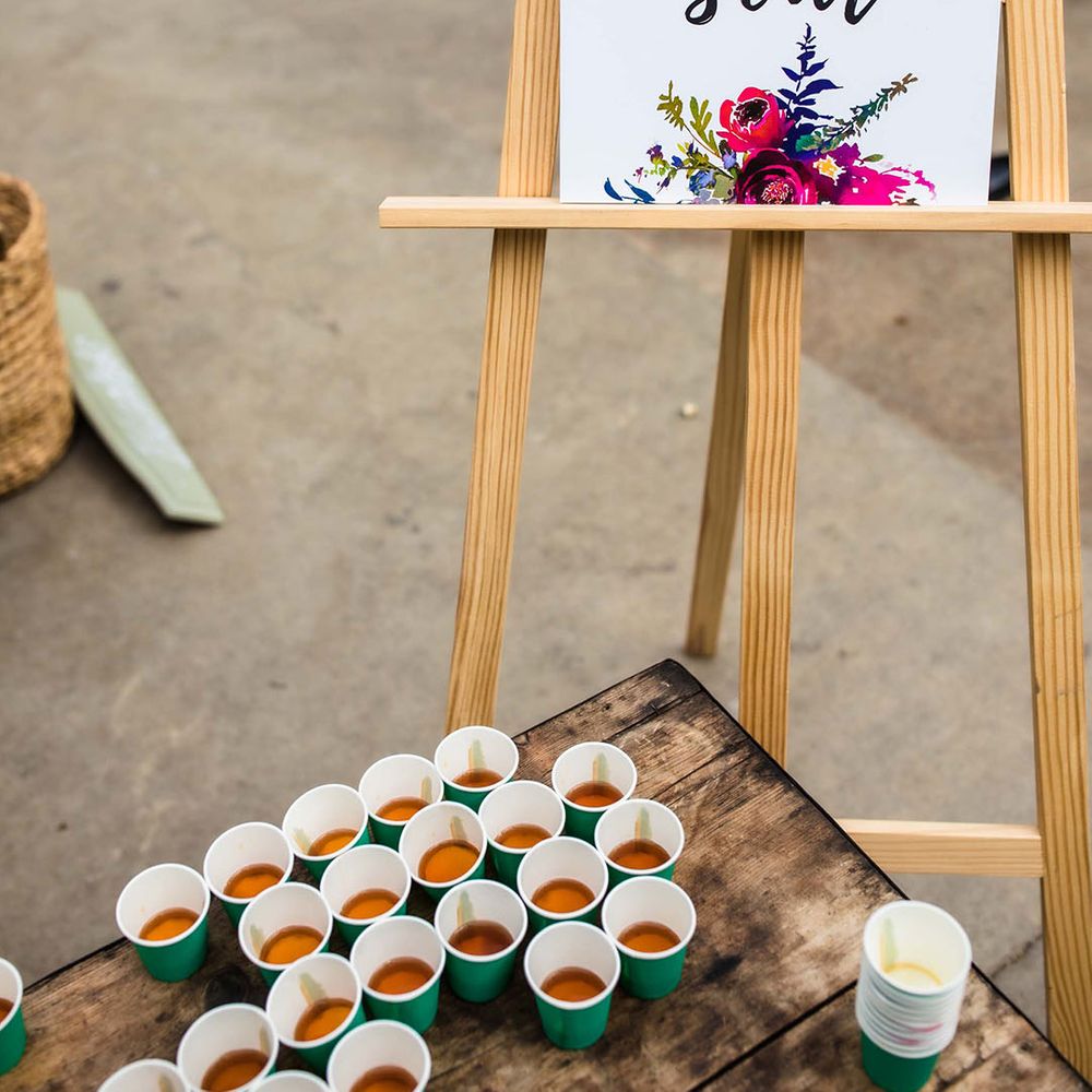 Shot station complete with floral illustrated wedding sign on wooden easel 
