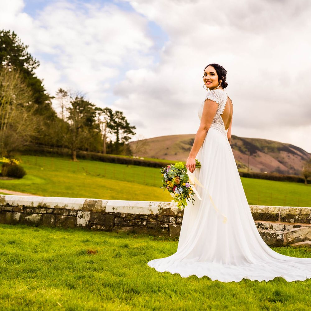 Bride wears lace open back wedding dress with puddle train 