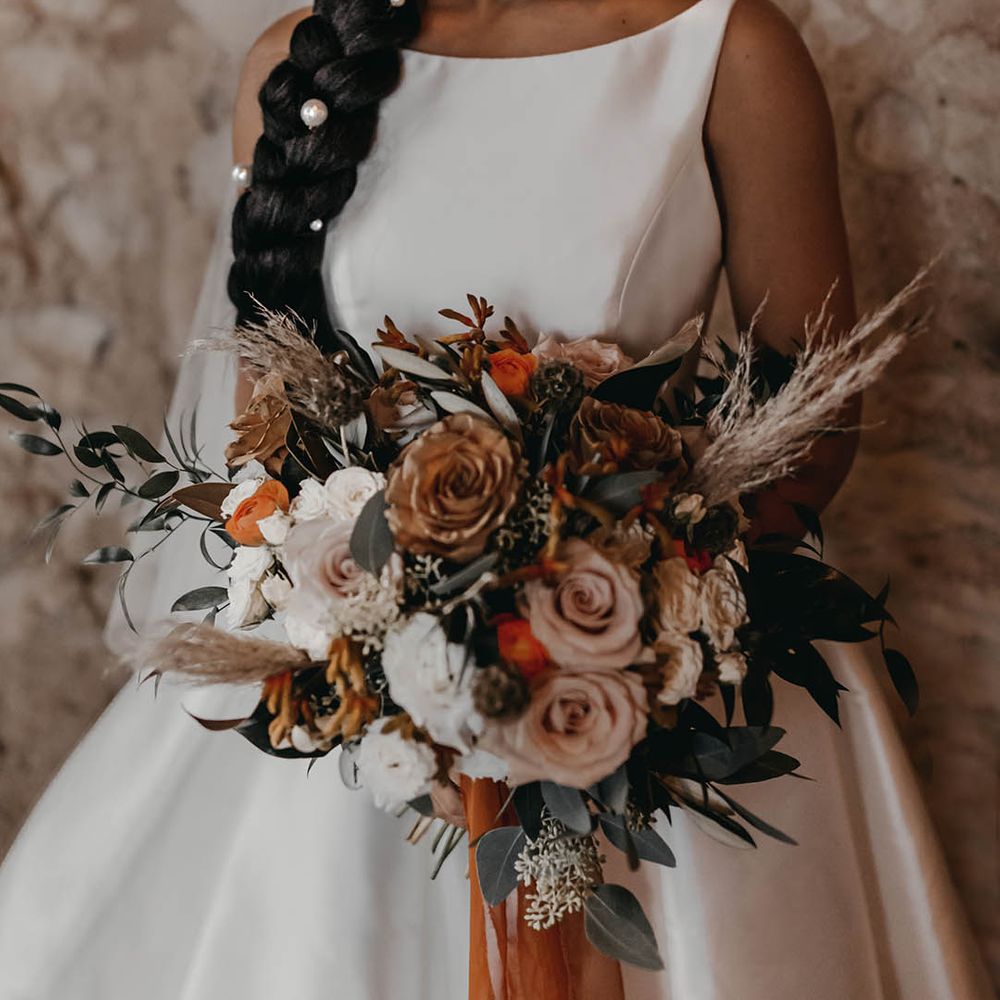 Bride in halterneck satin wedding dress with large pearl hair accessories 