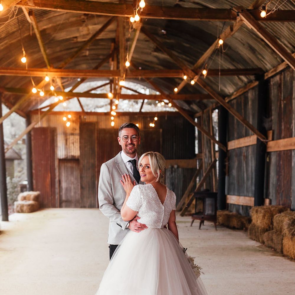 The bride and groom pose together for cute couple portraits on their winter wedding day
