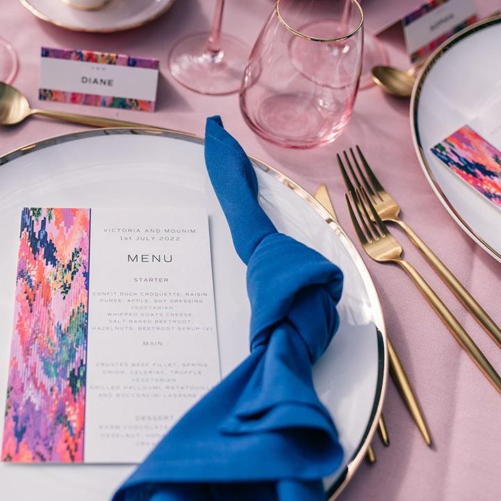 White gold edged plate with dark blue napkin, gold cutlery, and wedding menu designed by Papier 