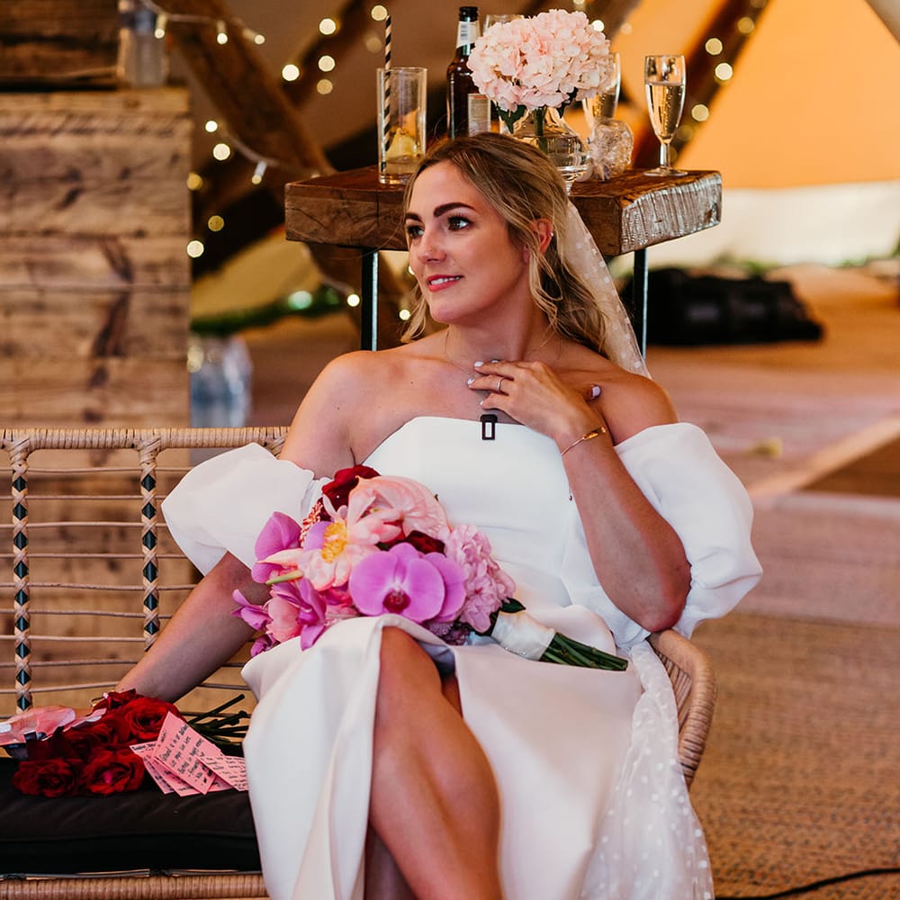 Bride in off the shoulder bridal gown holding pink wedding bouquet 