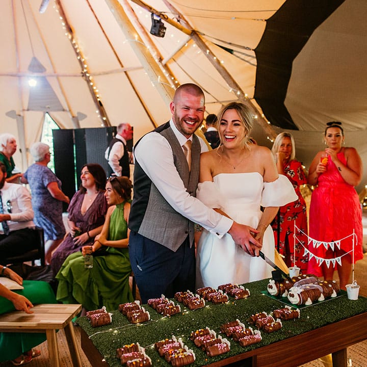 The bride and groom cut their Colin the Caterpillar wedding cakes 