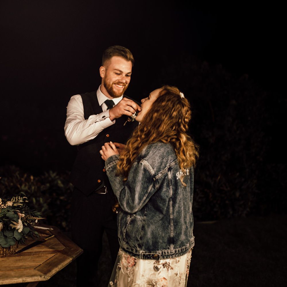 Bride & groom feed each other wedding cake 
