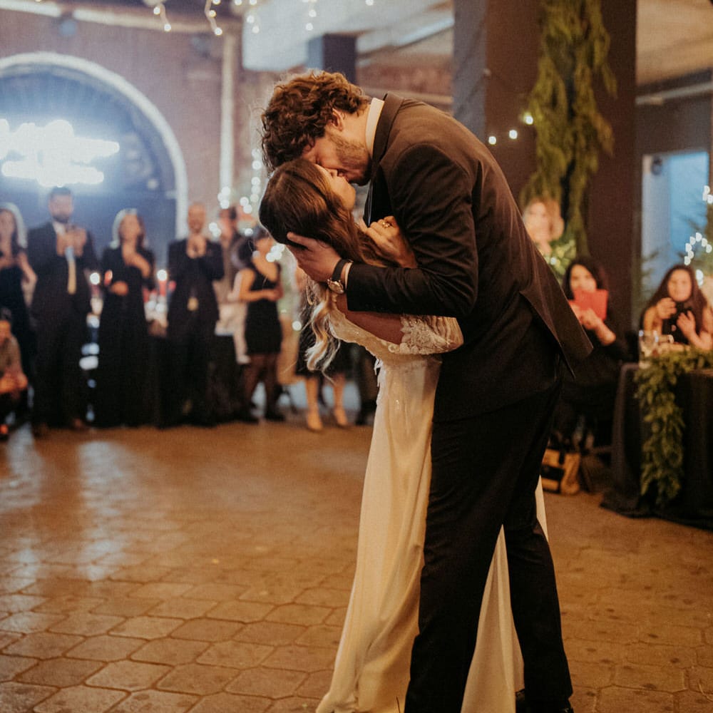 The groom dipping the bride on the dance floor for a kiss