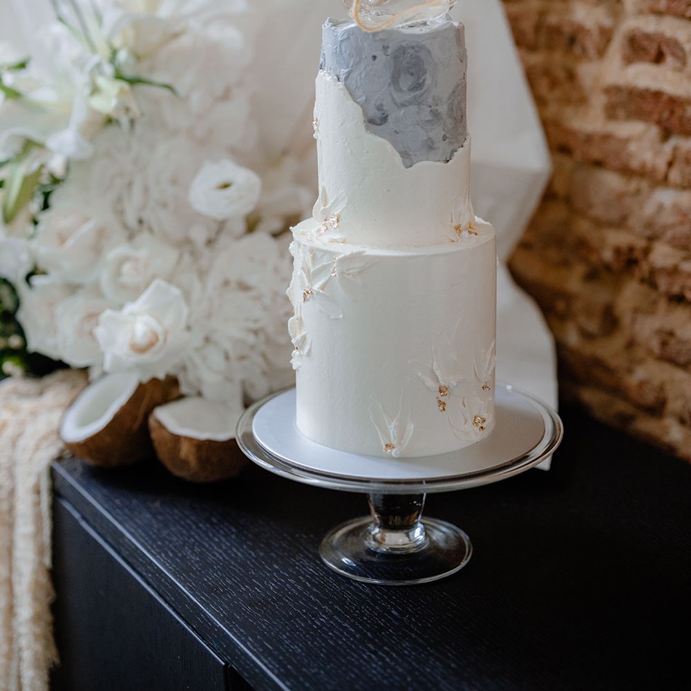 Two tier buttercream wedding cake with marble design and sugar sculpture cake topper 