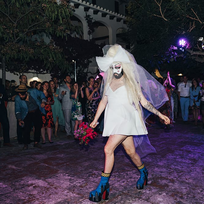 Goth Drag Queen walks along the floor for wedding reception in Menorca