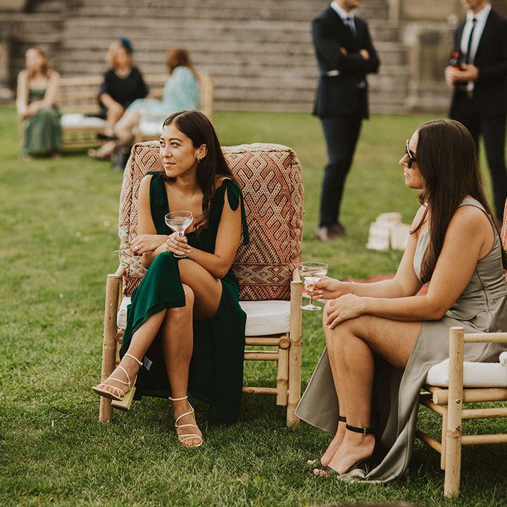 Bridesmaids sits outdoors 