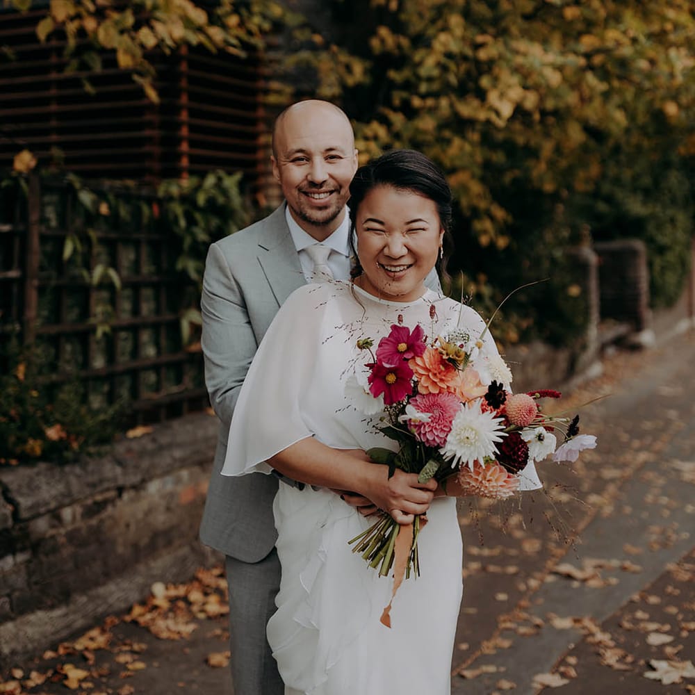 Groom wraps his arms around his bride on their wedding day