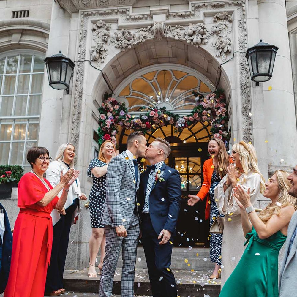 Grooms kiss as confetti is thrown around them