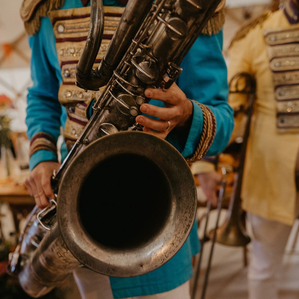 Live band wedding entertainment with man playing saxophone in blue uniform