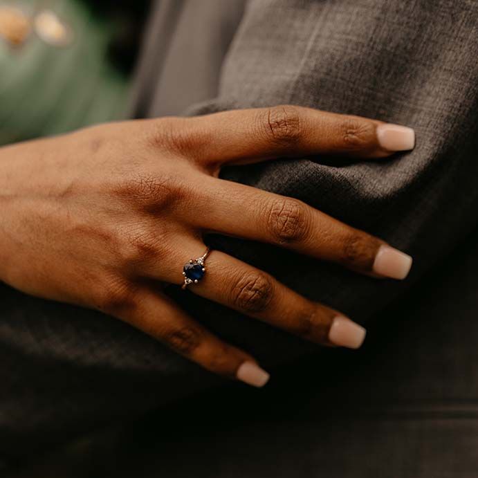 Bride showing dark blue gem wedding ring and golden bangle 