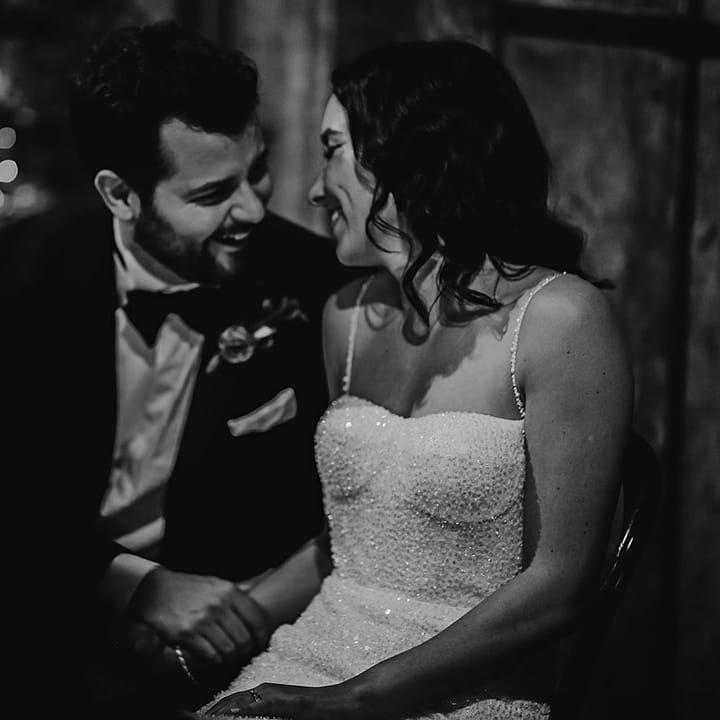 The bride and groom laugh together at their wedding reception 