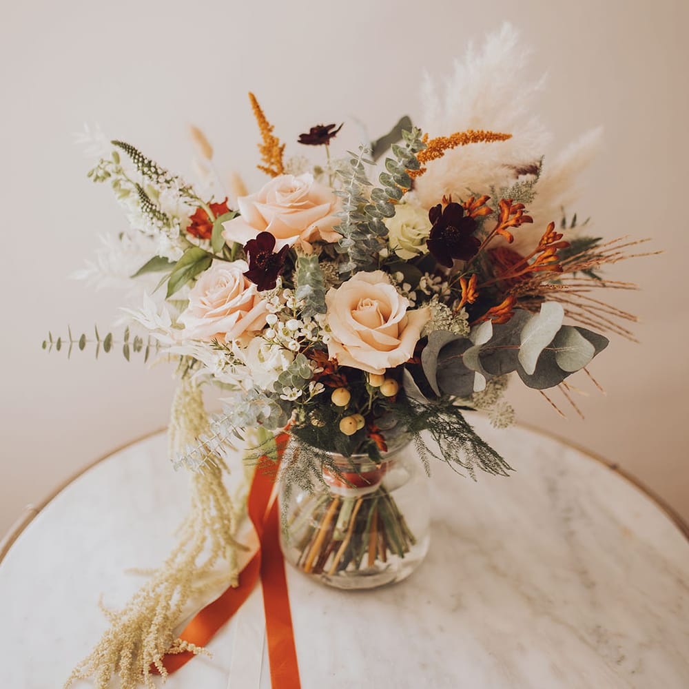 Autumnal styled bridal boutique with pampas grass and tied with orange silk ribbon