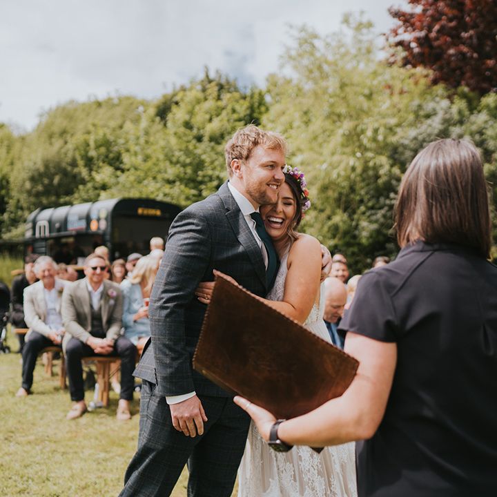 Bride hugs her groom outdoors during wedding ceremony 