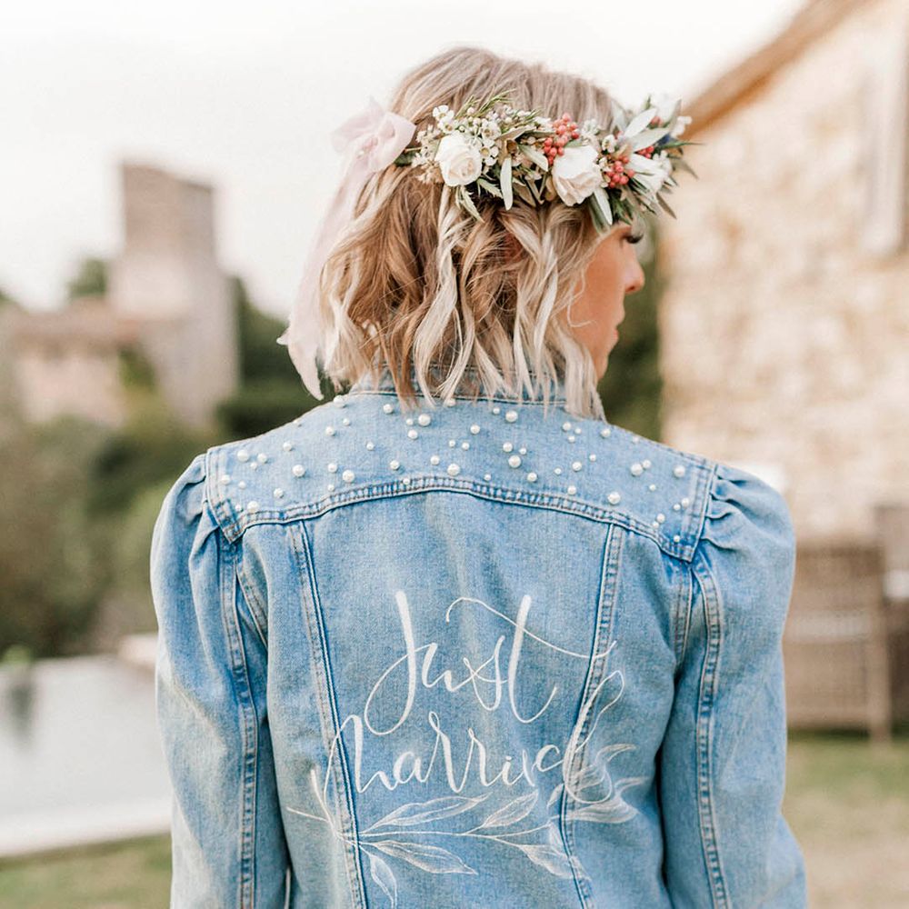 Bride in light blue denim jacket with puff sleeves with small pearls on the top of the bridal denim jacket 