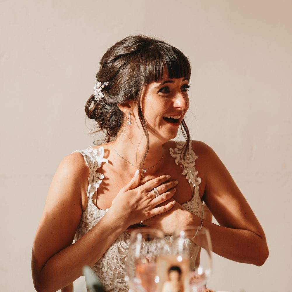 Bride smiling during wedding speeches 