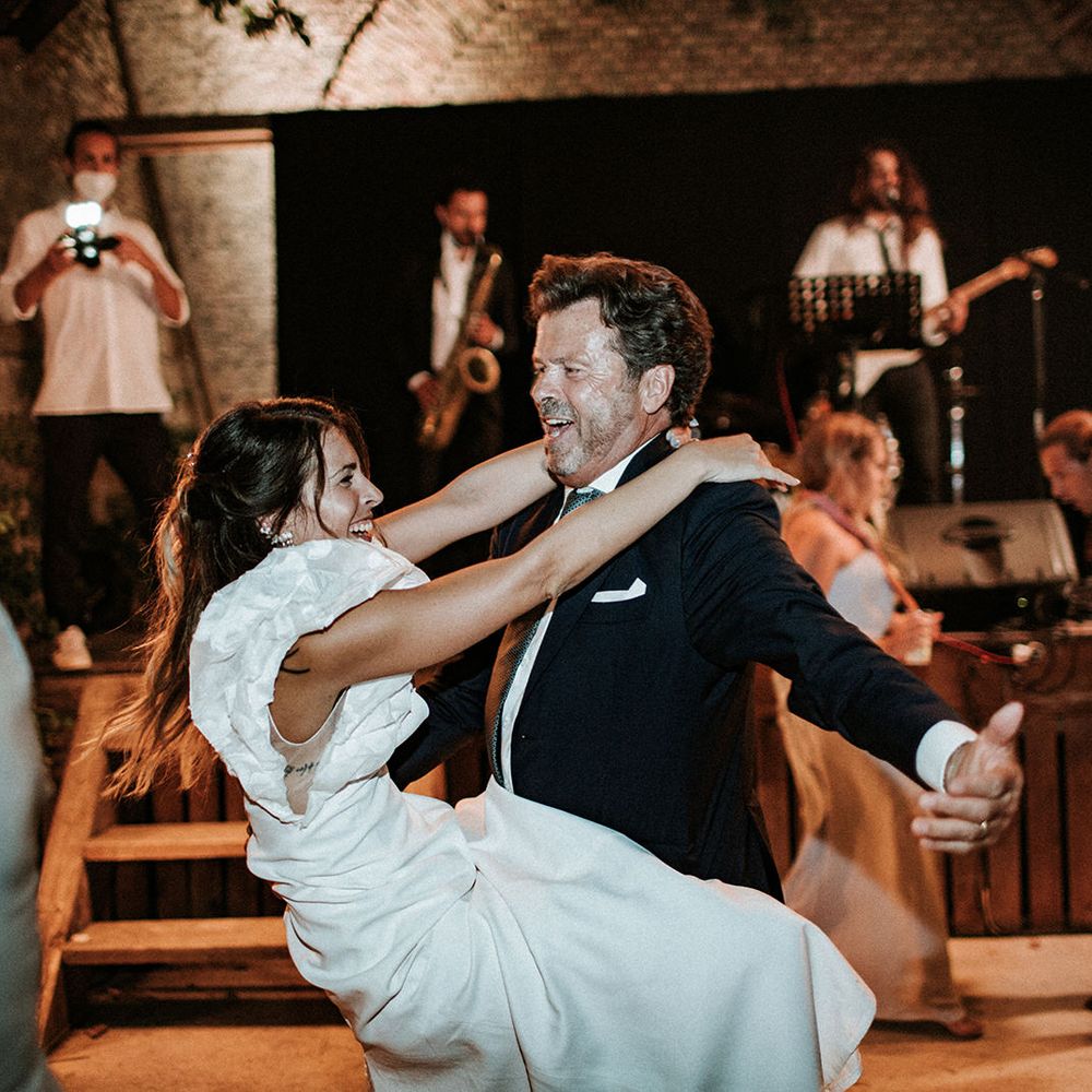 Father of the bride and his daughter in a ruffle sleeve wedding dress dancing at the Italian destination wedding 