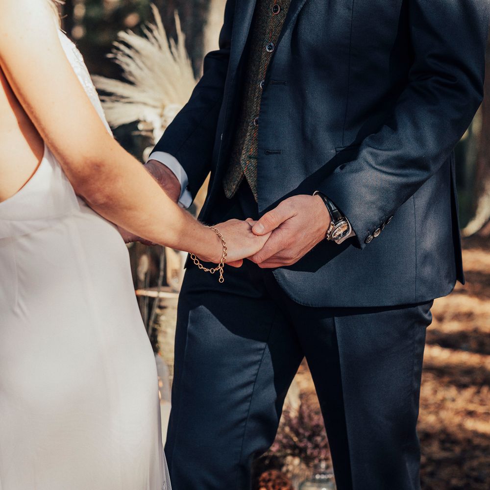 Bride & groom hold hands during wedding ceremony