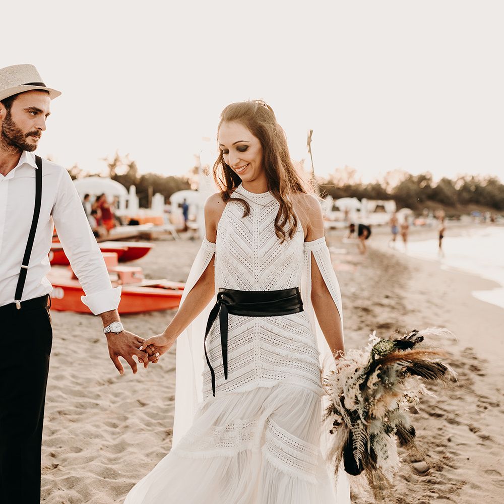 Bride in lace boho wedding dress with black belt