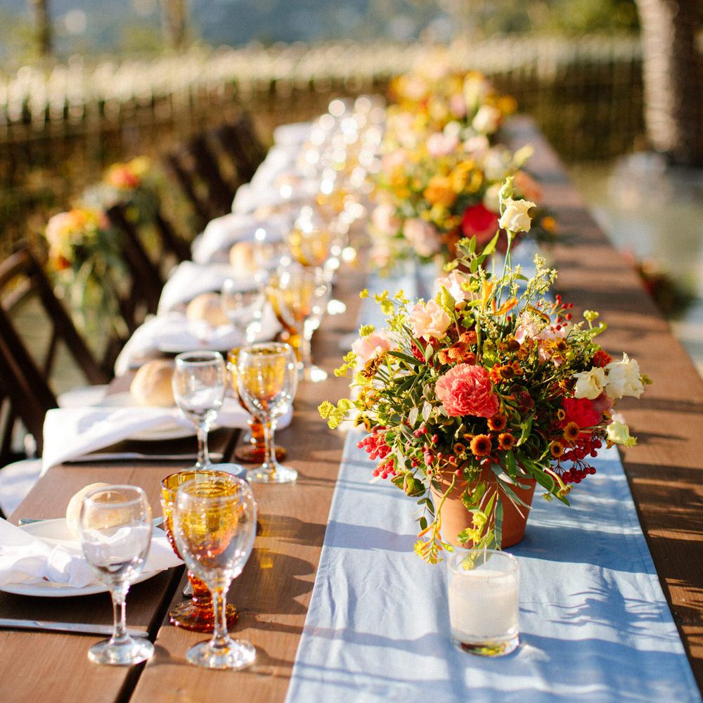 Simple and elegant wedding banquet table with linen table runner and terracotta flower pots
