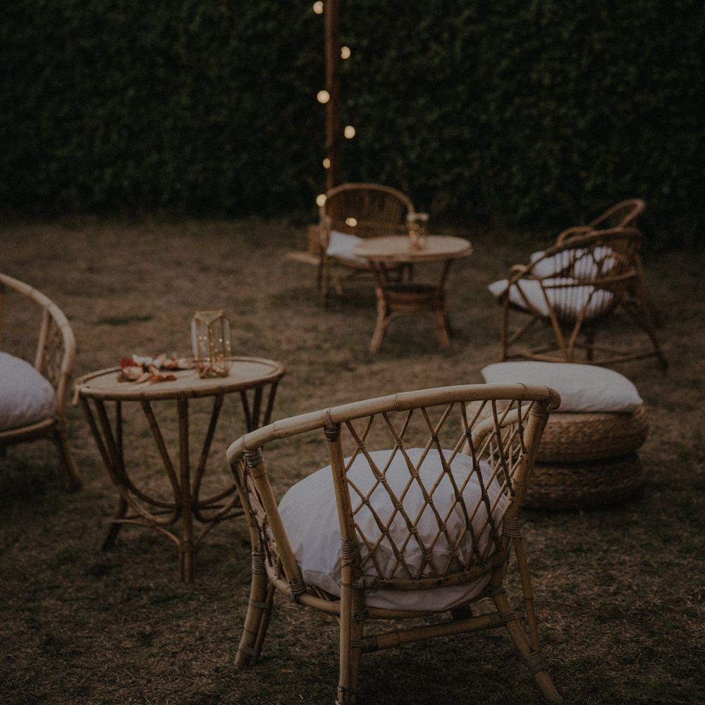 outdoor seating area with festoon lights and wicker chairs 