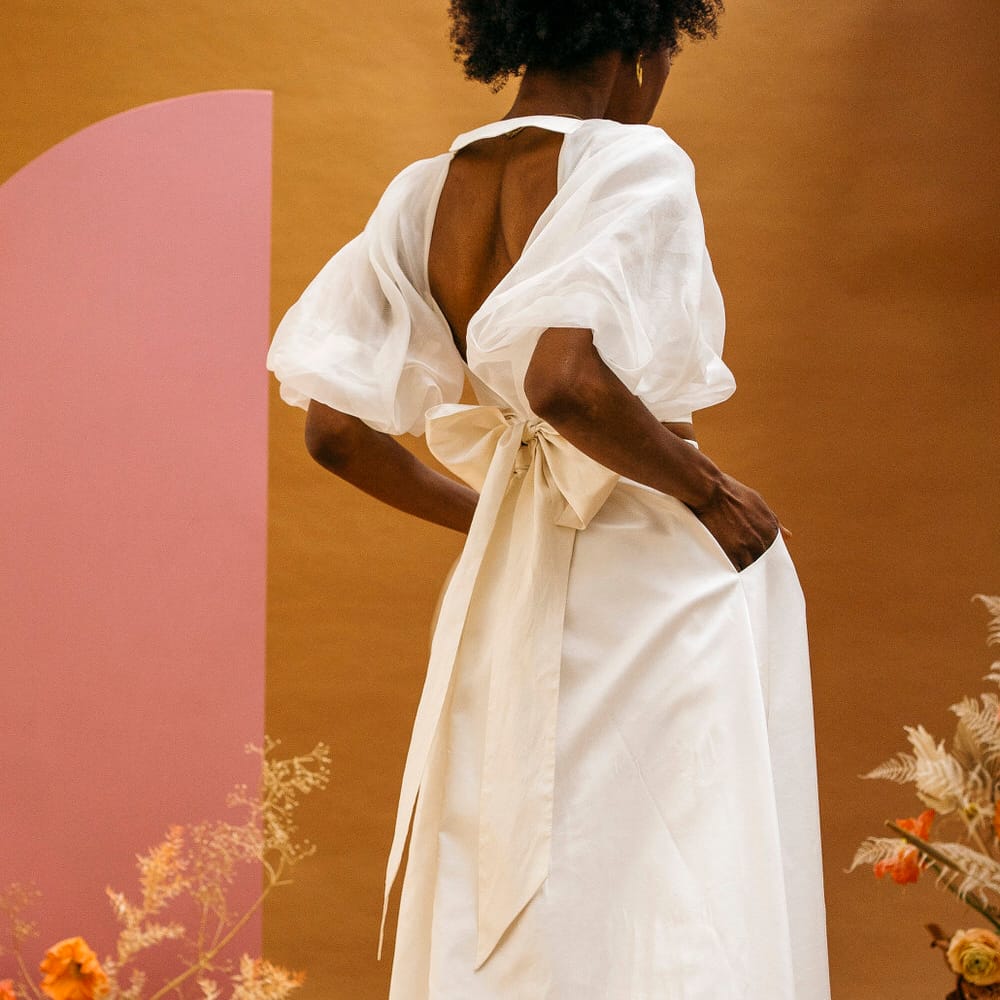 Bride facing away with her hands in her wedding skirt pockets