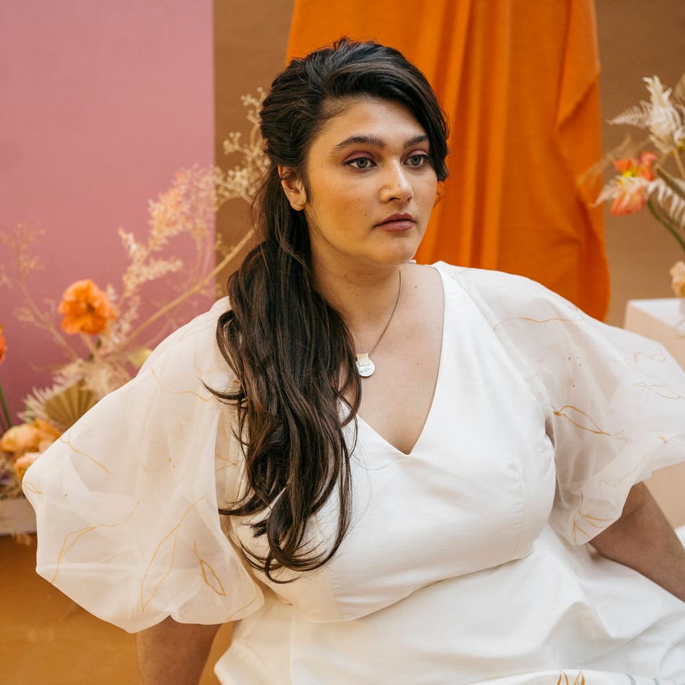 Bride with long flowing brown hair and neutral makeup wearing sheer puff sleeve wedding separates by Paper To Lace