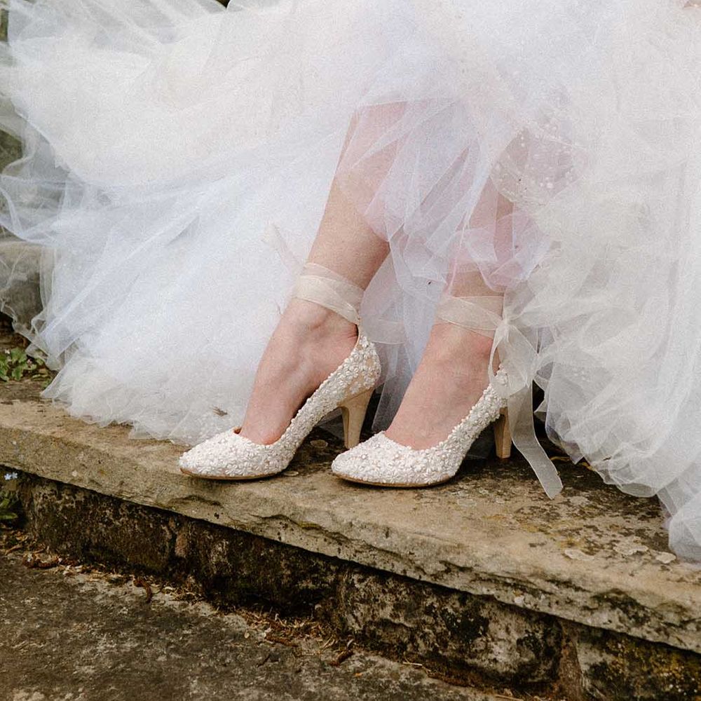 Bride in a tulle wedding dress wearing Di Hassall embellished wedding shoes with ankle strap 
