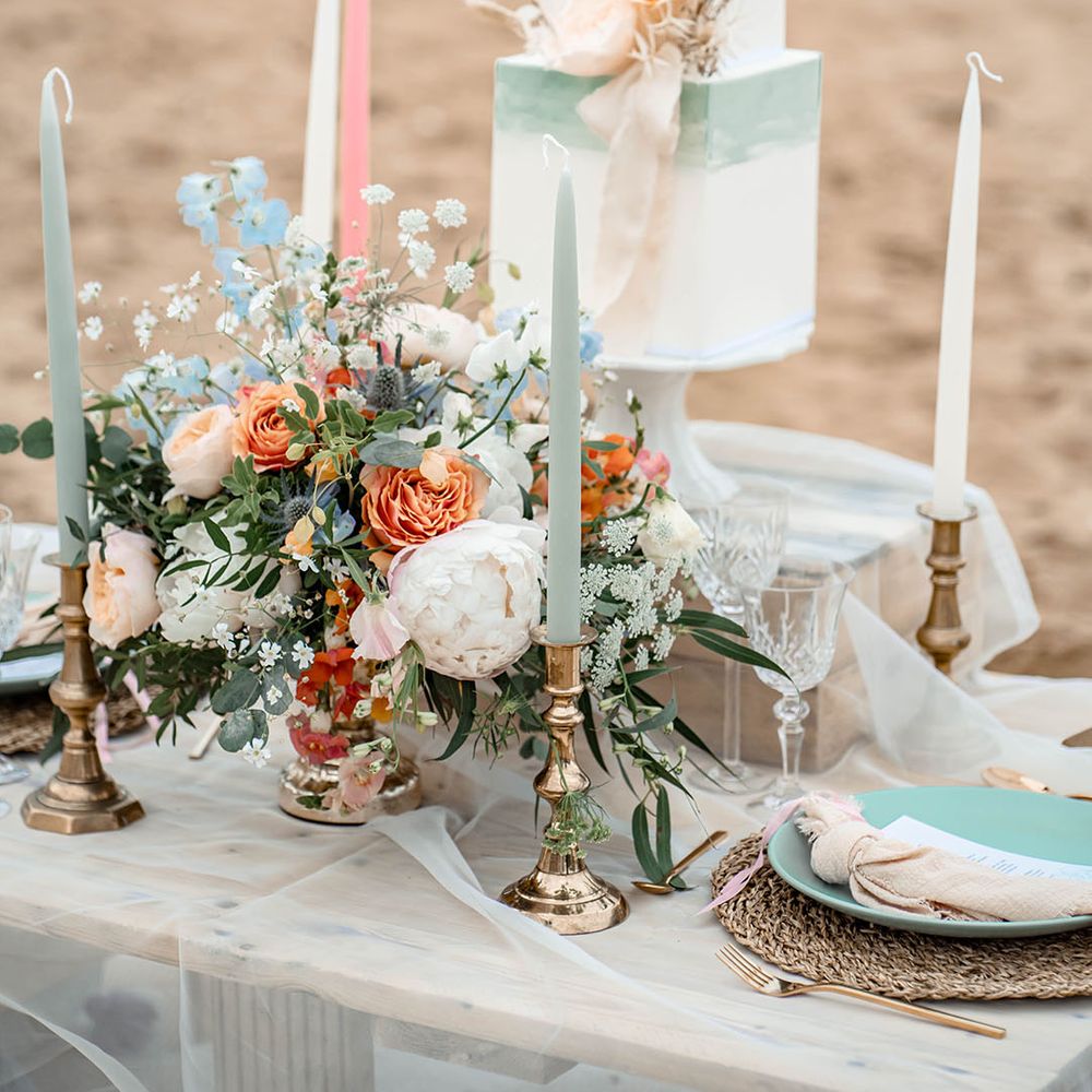 Pastel wedding table decor with floral centrepiece, taper candles and ombre buttercream wedding cake 