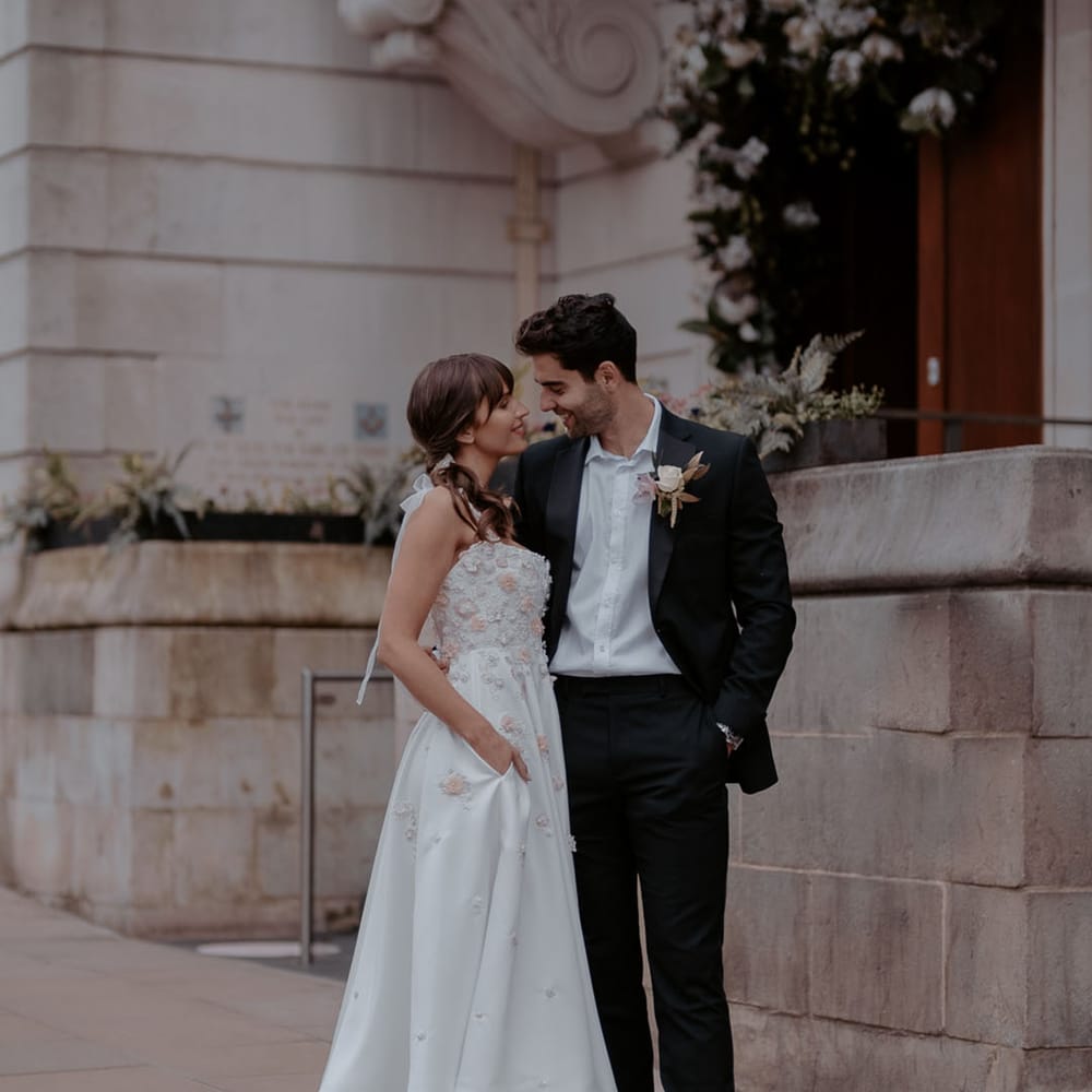 Manchester Hall elopement with bride in a midi wedding dress with flower appliqué detail and groom in a black suit and white shirt 